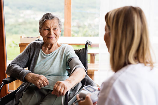 Caregiver assisting elderly woman in wheelchair, providing heart-centered End-of-Life Doula care and holistic palliative support in Montreal, Quebec.