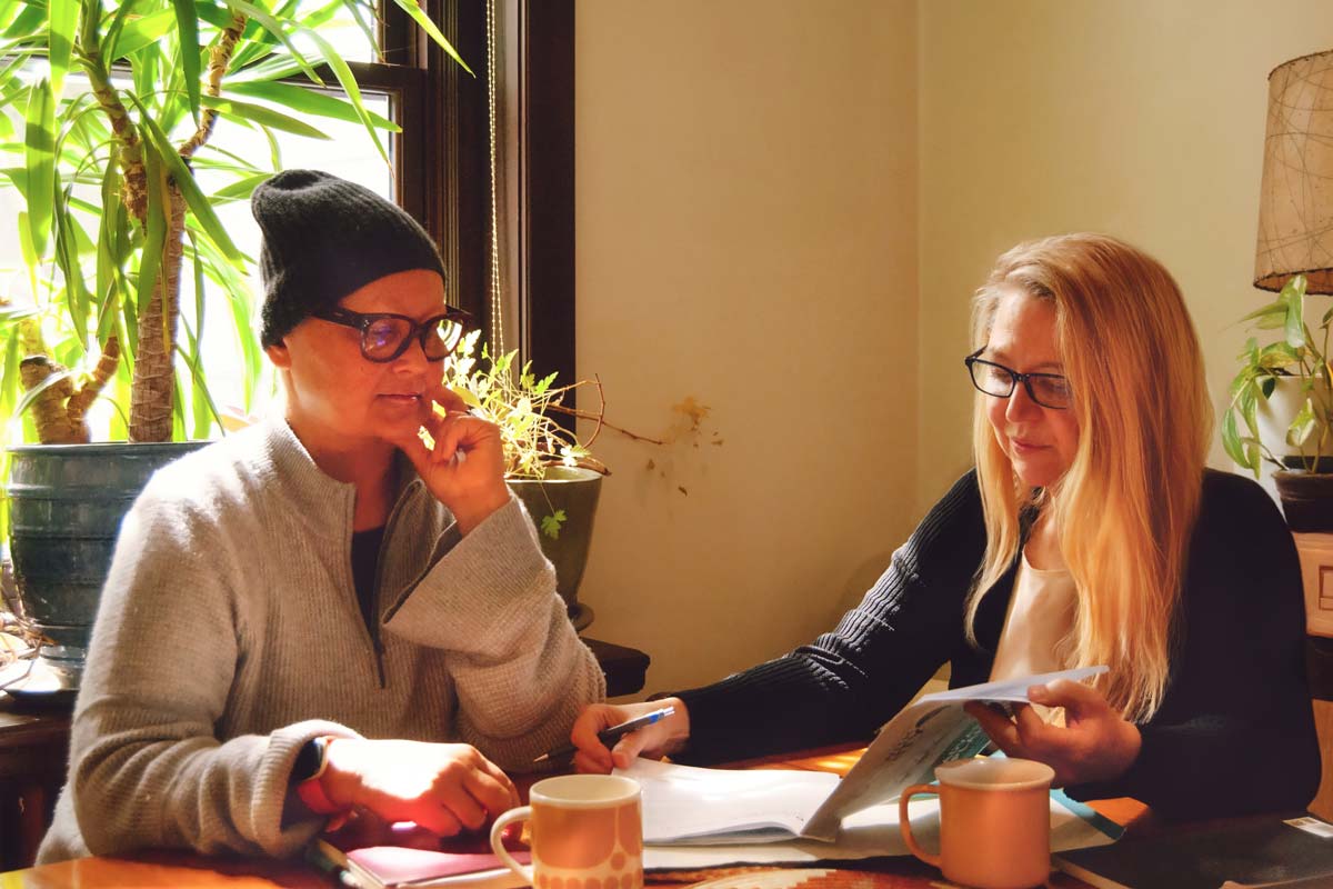 End-of-Life Doula, Nina de Cocq, and a client discussing Advance Care Planning at a kitchen table.